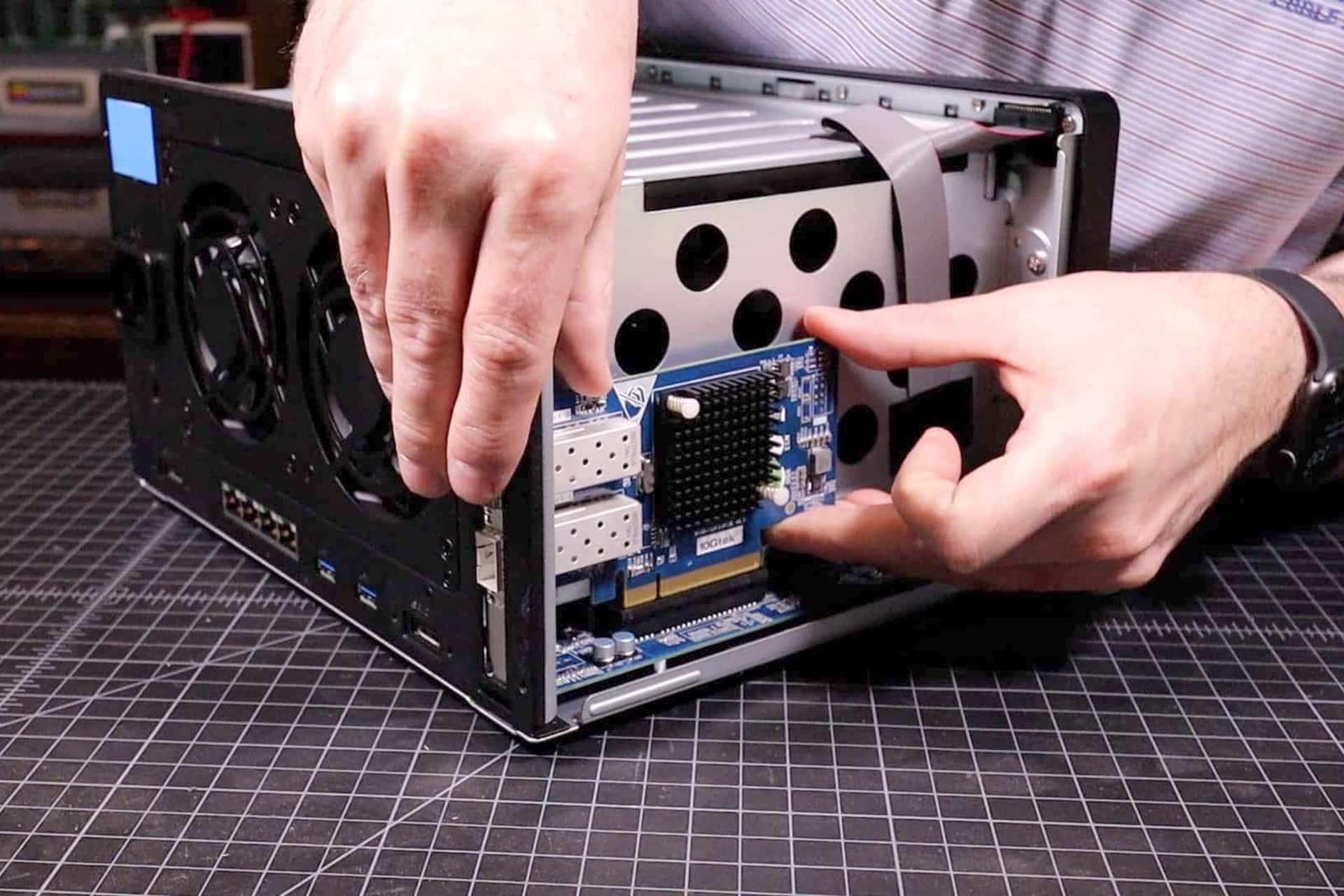 آیا در سال ۲۰۲۴ به کارت شبکه نیاز داریم؟_مستطیل زرد 4 یک شخص درحال نصب کارت شبکه در یک دستگاه NAS