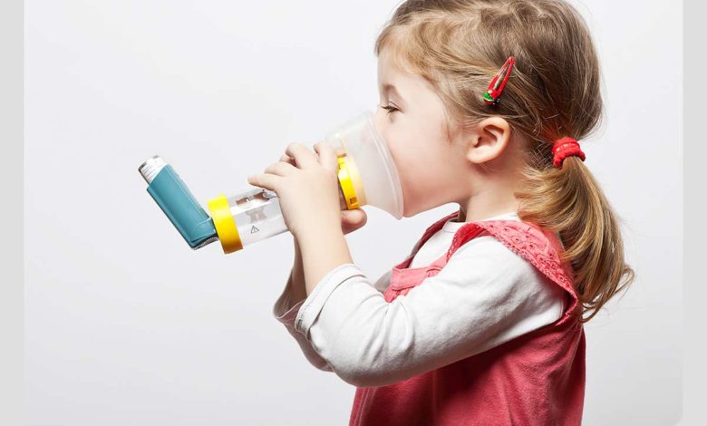 کودک در حال استفاده از اسپری استنشاقی به دلیل ظهور برخی از علائم آسم در کودکان