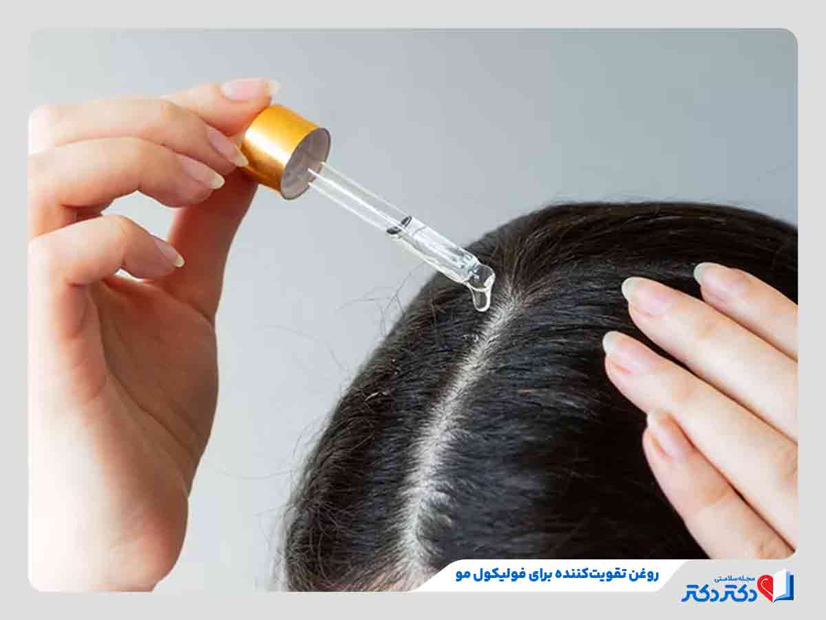 زنی در حال استفاده از روغن برای تقویت فولیکول مو